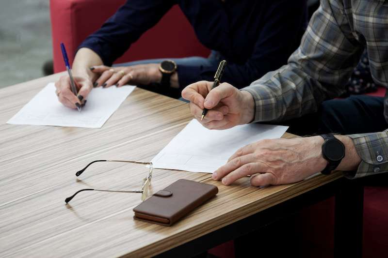 Two people signing divorce paperwork